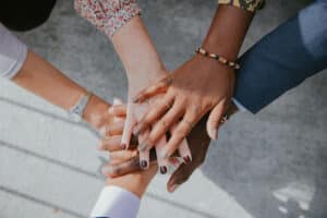people's hands on top of one another as a symbol of working together as a unit