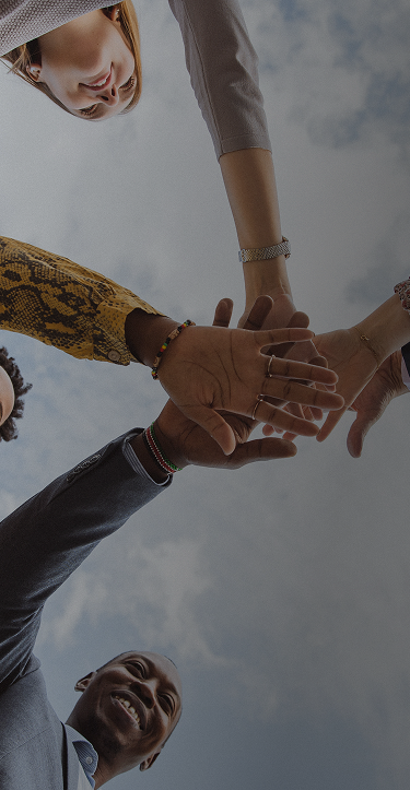 Mehrere Hände von verschiedenen Personen liegen im Kreis aufeinander als Zeichen von Teamwork und Leadership-Kultur bei Think Beyond.